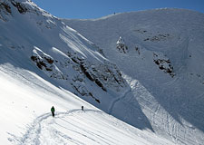 Skiers Traversing Below Mountain Quail