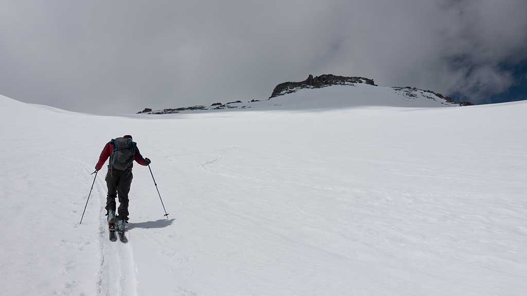 Ascending the summit snowfield toward The Thumb
